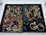 deux plateaux de bijoux posés sur une table