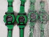 two green and black watches sitting next to each other on a white surface