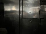 a large stainless steel refrigerator in a dark room