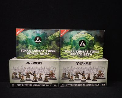Deux boîtes de figurines Warhammer sont posées côte à côte sur une surface noire