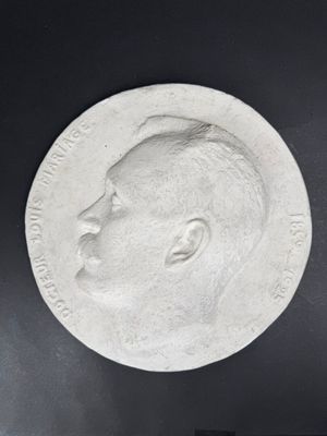 a close up of a silver medal with a man ' s face on it