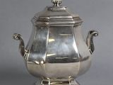 an antique silver teapot with a lid on a stand