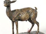 bronze statue of a goat on a base on a white background