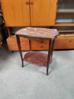 une petite table avec un plateau en marbre dans une pièce