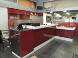 a red and white counter in a restaurant with a black chair