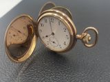 une montre de poche en or posée sur une table