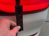 a person holding a ruler in front of a car