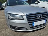 a silver audi parked in a parking lot with other cars