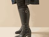 the woman is wearing a pair of black boots and a denim jacket