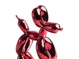 a red balloon dog sculpture on display on a white background