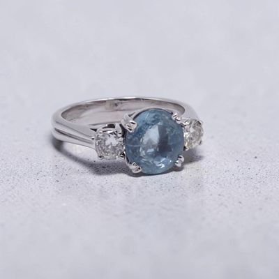 gros plan d'une bague en saphir bleu et diamant sur une surface blanche