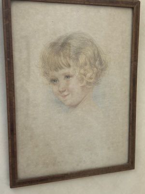portrait d'un jeune garçon dans un cadre en bois accroché au mur