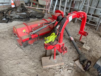 une machine rouge qui est à l'arrêt dans la boue