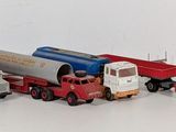 several toy trucks are lined up in a row on a white surface