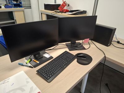two computer monitors and a keyboard on a desk