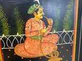 painting of a man playing a musical instrument on a black background