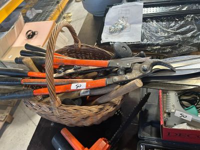 un panier rempli de ciseaux et d'autres outils posé sur une table