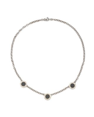 un collier noir et blanc composé de trois pierres noires montées sur une chaîne en argent