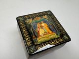 a small box with a painting on it sitting on a table
