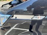a man taking a picture of his reflection in the mirror of a car