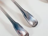 three spoons and a fork on a white table