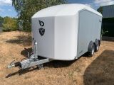 a white trailer that is parked in the grass