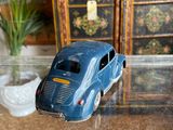 a toy car sitting on a glass table next to a potted plant