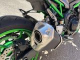 a green and black motorcycle parked on the side of the road