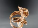 a close up of a gold ring on a reflective surface