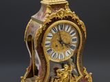 une horloge en or surmontée d'une figurine