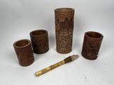 quatre vases en bois et un pinceau posés sur une table