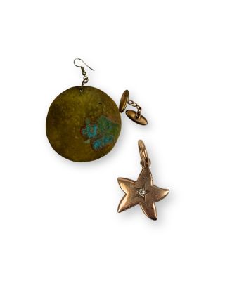deux boucles d'oreilles et une étoile sont posées sur une surface blanche