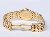 a close up of a gold wrist watch on a white surface