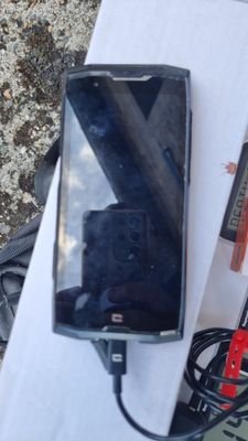 a cell phone sitting on top of a table next to a charger
