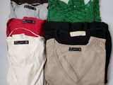 four pairs of sweaters sitting on top of a white table