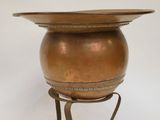 an image of a brass pot on a stand with a white background