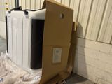 a microwave sitting on top of a carton in the middle of the floor