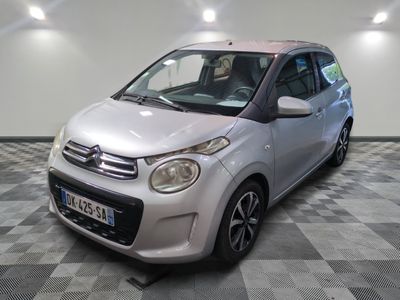 la petite voiture argentée est garée sur un sol en damier