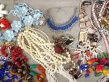 a lot of necklaces and bracelets that are on a table