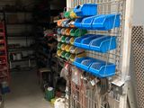 un rayonnage métallique sur lequel sont posés des bacs en plastique, dans un garage