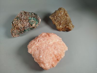 three different colored rocks sitting on a plate