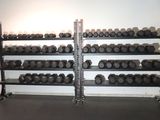 a rack of dumbs in a gym room with a wall of dumbs
