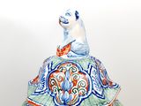 an image of a ceramic jar with a cat on top
