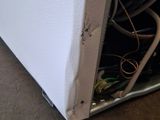 a white refrigerator with a bunch of wires inside of it