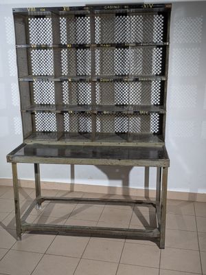 une étagère en métal avec un plateau en verre, posée sur un sol carrelé