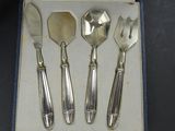 four silverware pieces in a box on a table