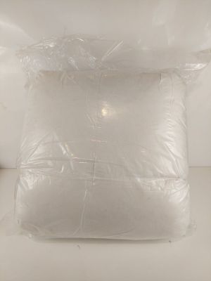 un oreiller blanc emballé dans du plastique, posé sur le lit