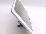 a tablet computer sitting on a stand on a white surface