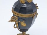 a black and gold urn with a bird on it