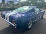 une photo d'une Mustang bleue garée sur un parking